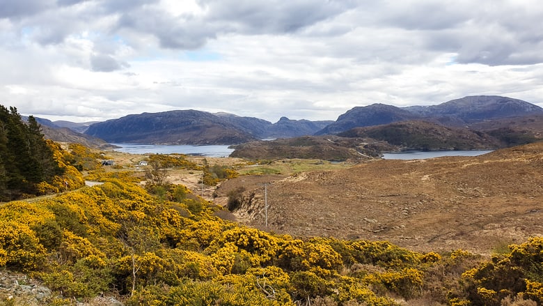 A road following the North Coast 500 route winding through a mountainous landscape 