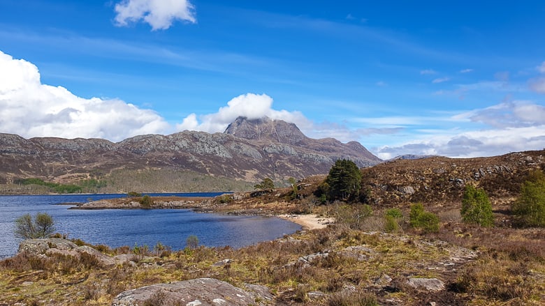 A cloud-covered mountain peak of Slioch across a loch